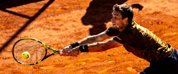 网球运动员在红土场上奋力击球，身体舒展，表情专注